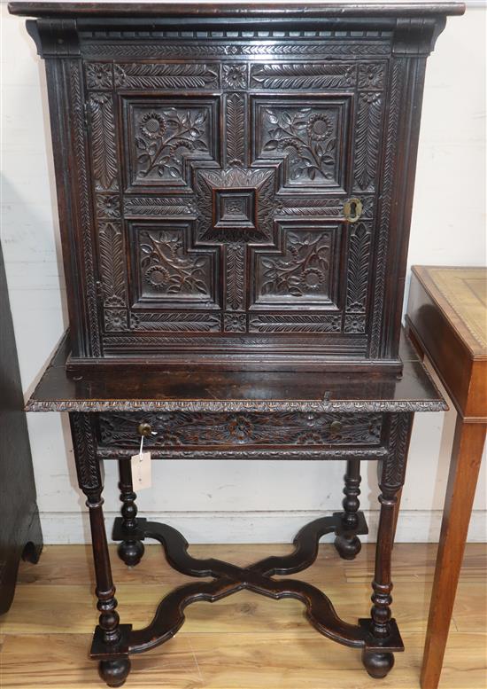 A 17th century design carved oak cabinet on stand W.72cm